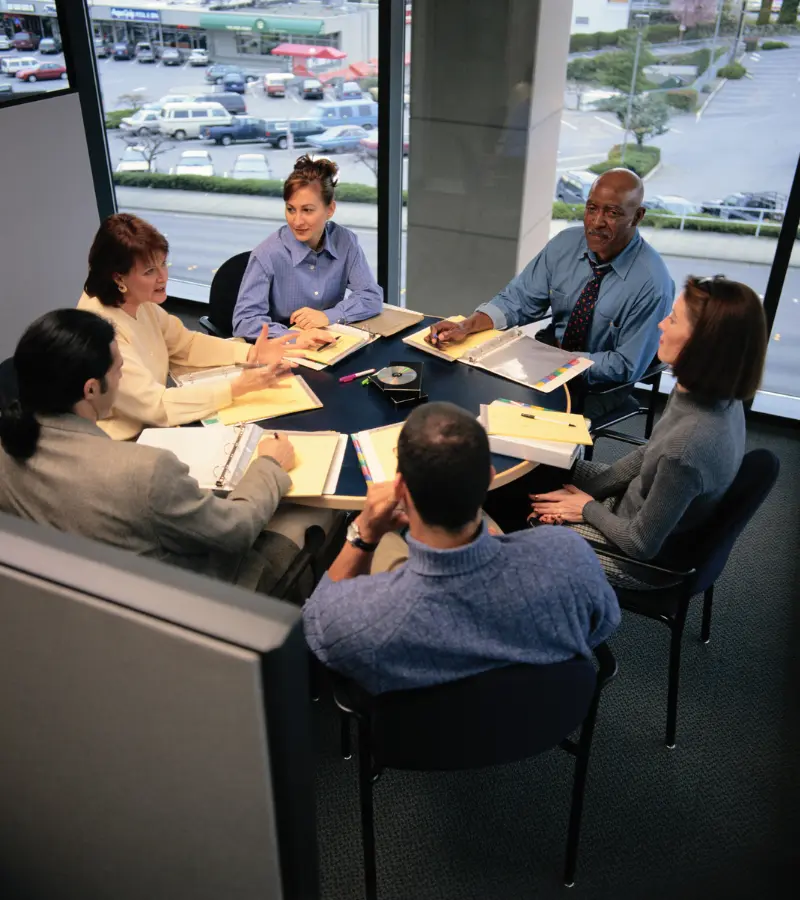 Senior team members are planning business strategy in the meeting room at the round table.