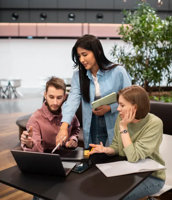 Three tech talents discussing project-based hiring while looking at a laptop screen.