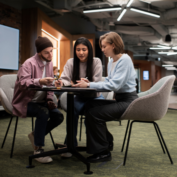 Coderwan team having a hiring discussion around a small table in the office